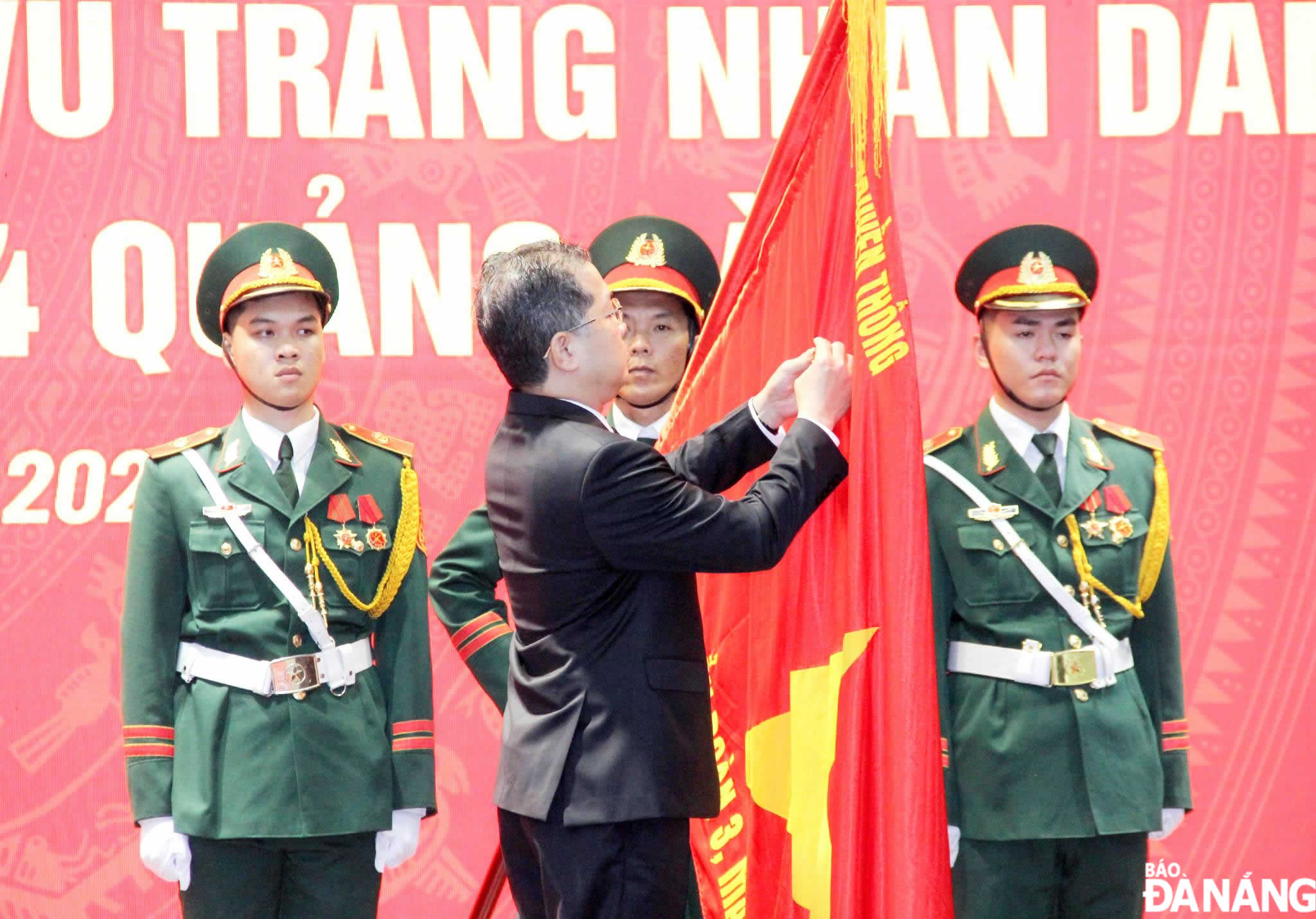 Under the authorisation of the State President, Da Nang Party Committee Secretary Nguyen Van Quang attaches the medal to the traditional flag of Battalion No.3, the 44 Quang Da Front. Photo: LE HUNG