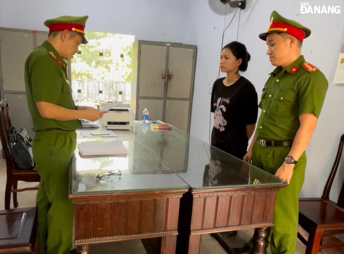 Cơ quan Cảnh sát điều tra, Công an quận Liên Chiểu tống đạt quyết định khởi tố vụ án, khởi tố bị can đối với Nguyễn Thị Kim Ngân (giữa). Ảnh: L.H