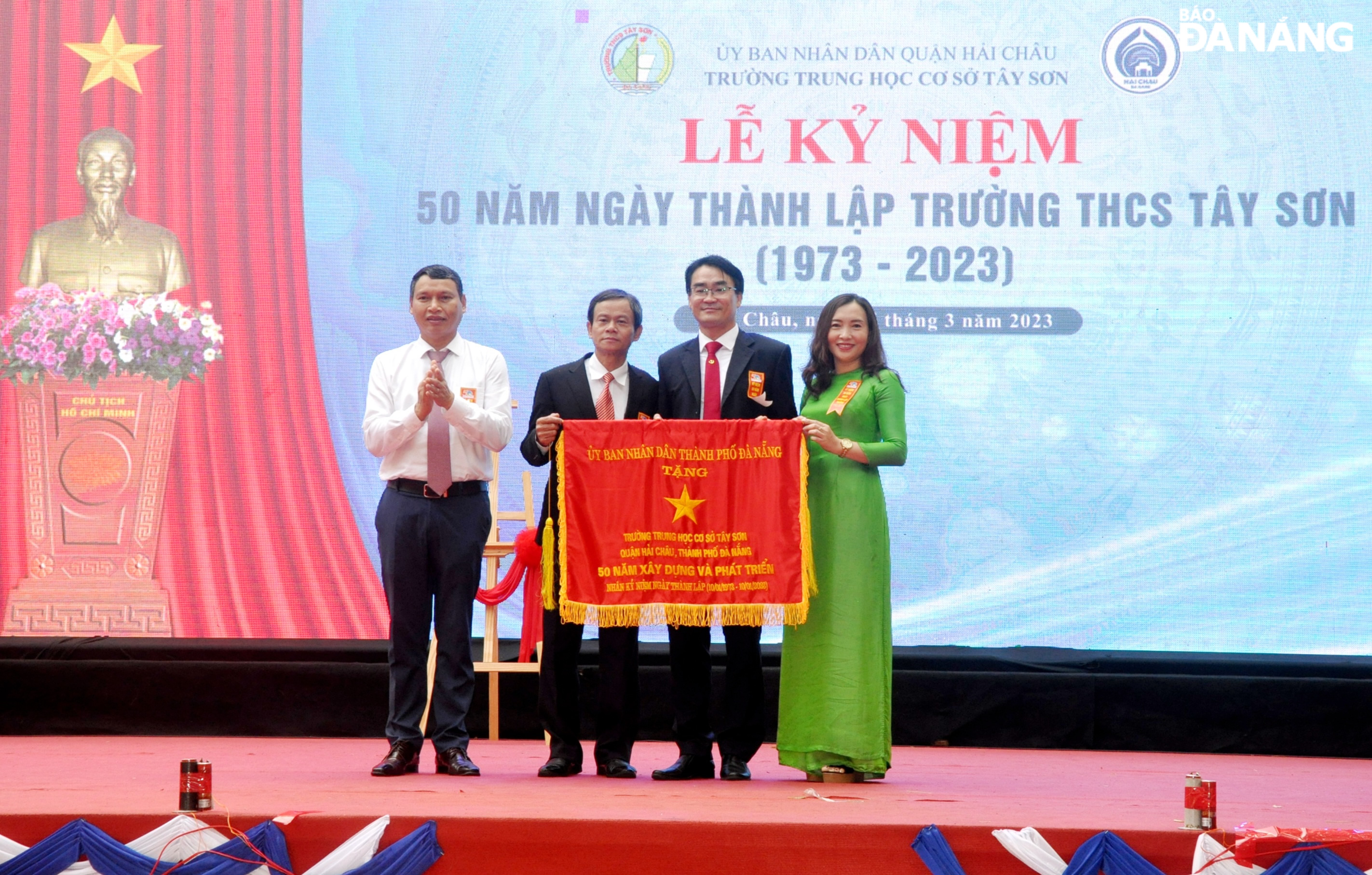 Phó Chủ tịch Thường trực UBND thành phố Hồ Kỳ Minh (bên trái) trao tặng Cờ truyền thống cho Trường THCS Tây Sơn. Ảnh: LÊ HÙNG