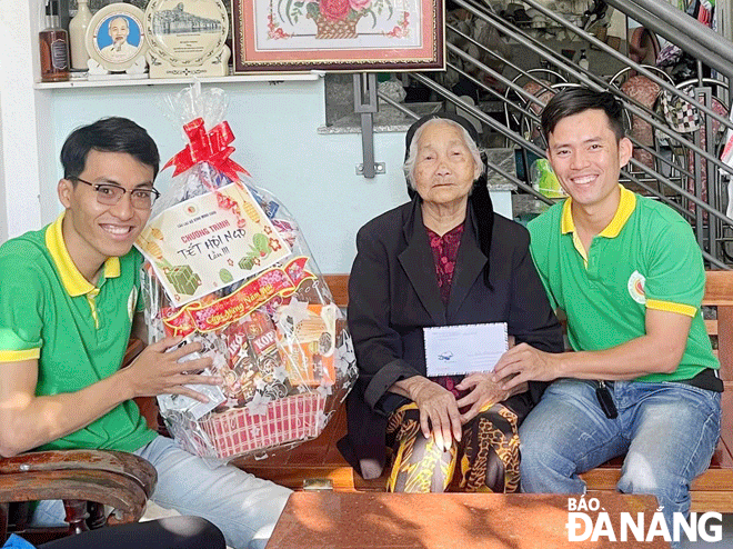 Anh Lê Văn Bi (bên phải) trao quà Tết cho hộ khó khăn tại địa phương. Ảnh: K.M	