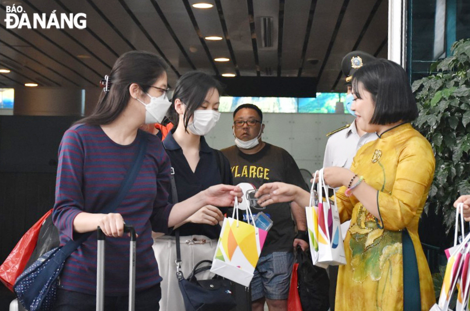 Japanese tourists arriving in Da Nang on the first direct flight from Narita are presented with gifts. Photo: THU HA