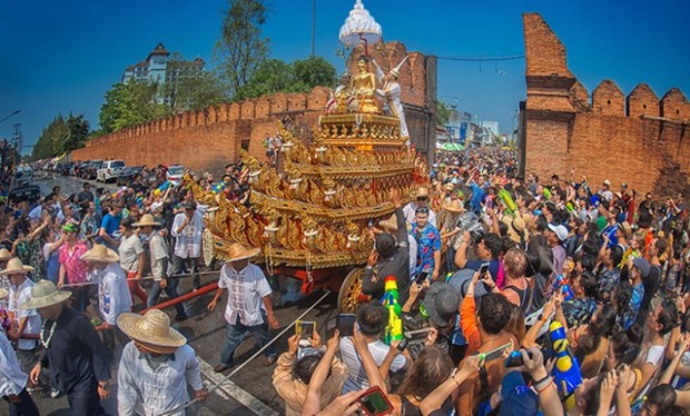 Locals and visiting tourists sprinkle water onto Phra Phutthasihing during the Songkran Festival at Tha Phae Gate, Chiang Mai. (Photo: tatnews.org)