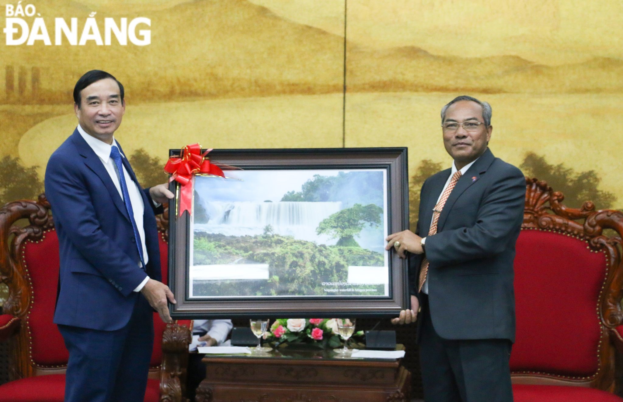 Bí thư, Tỉnh trưởng tỉnh Attapeu (Lào) Let Xaynhaphon (bên phải) tặng quà lưu niệm cho Chủ tịch UBND thành phố Lê Trung Chinh. Ảnh: T.PHƯƠNG