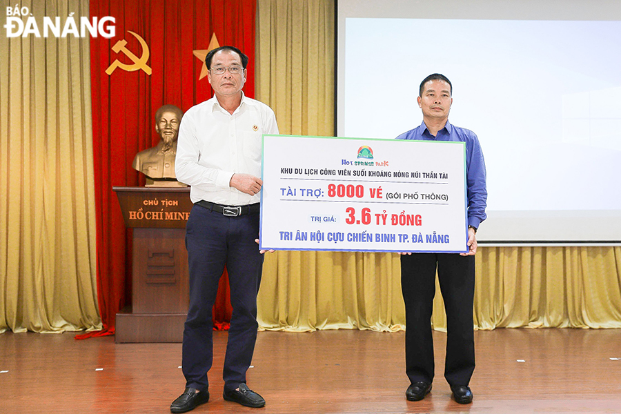 Mr. Pham Khac Duong (right), the Director of DHC Suoi Doi Corporation presents a symbolic board to the representative of the Da Nang Veterans Association on the ticket donation. Photo: THU HA