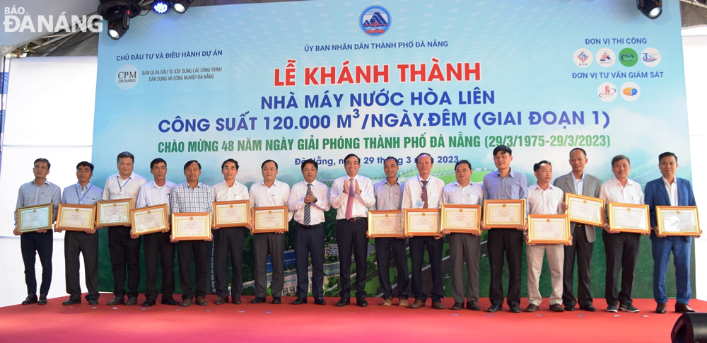 Da Nang Party Committee Deputy Secretary cum People's Council Chairman Luong Nguyen Minh Triet (8th, left), municipal People's Committee Chairman Le Trung Chinh (9th, left) awarding Certificates of Merit to 10 collectives and 5 individuals in recognition of their outstanding achievements in well performing assigned tasks. Photo: HOANG HIEP