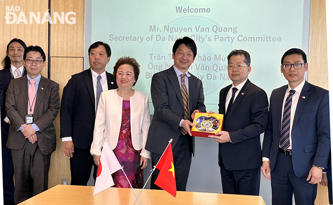 Da Nang Party Committee Secretary Nguyen Van Quang (second, right) presents a memento to the leader of Sumitomo Corporation