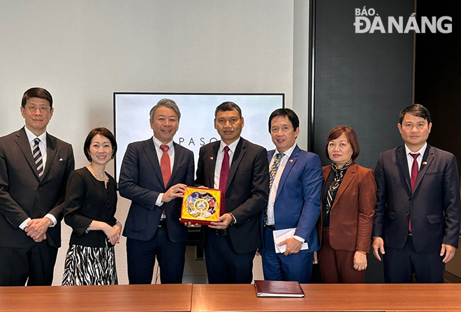 Da Nang Peoples Committee Vice Chairman Ho Ky Minh (fourth, right) presents a souvenir gift to leaders of Pasona Group.