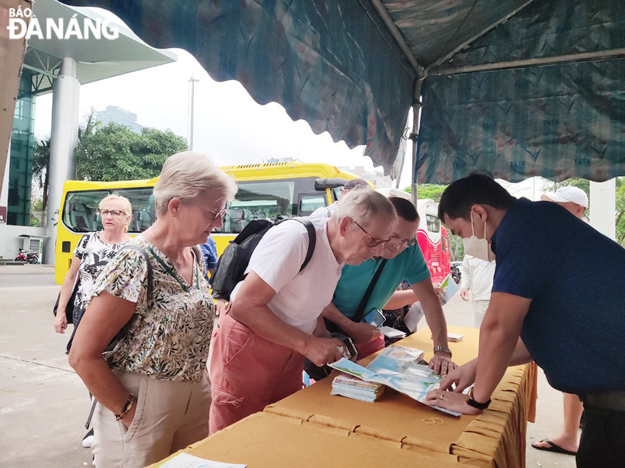 Staff of the Tourist Support Centre provide more information about Da Nang to foreign guests at the area in front of the Trung Vuong Theatre. Photo: THU HA