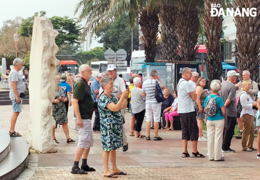 Foreigners are seen going for a stroll on pavement of Bach Dang Street to admire the beauty of local bridges, and then visiting the Han Market. Photo: THU HA