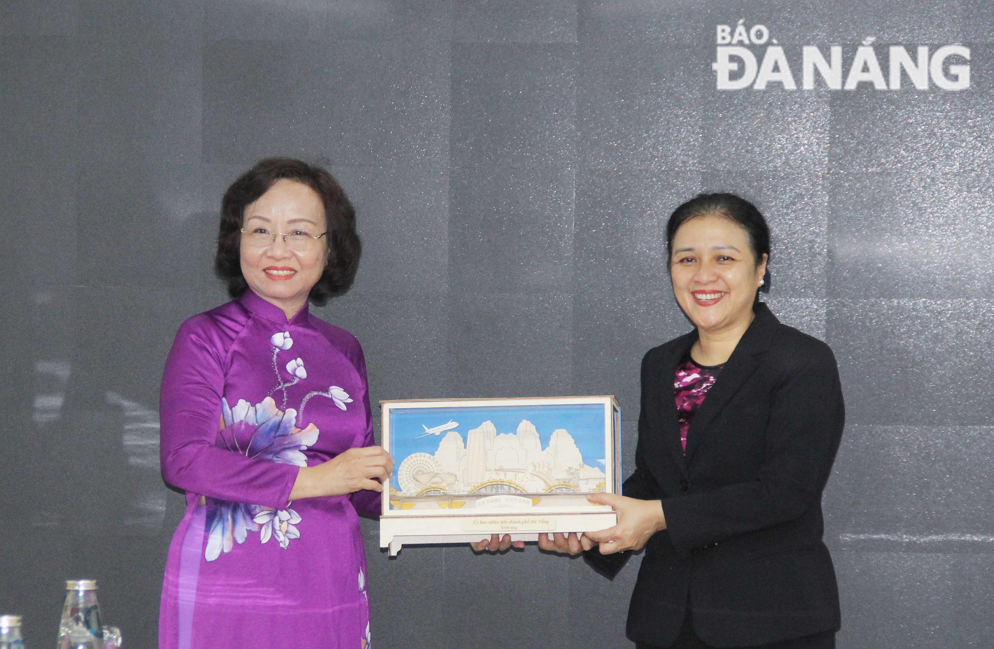 Phó Chủ tịch UBND thành phố Ngô Thị Kim Yến (bên trái) trao quà lưu niệm cho bà Nguyễn Phương Nga. Ảnh: X.HẬU