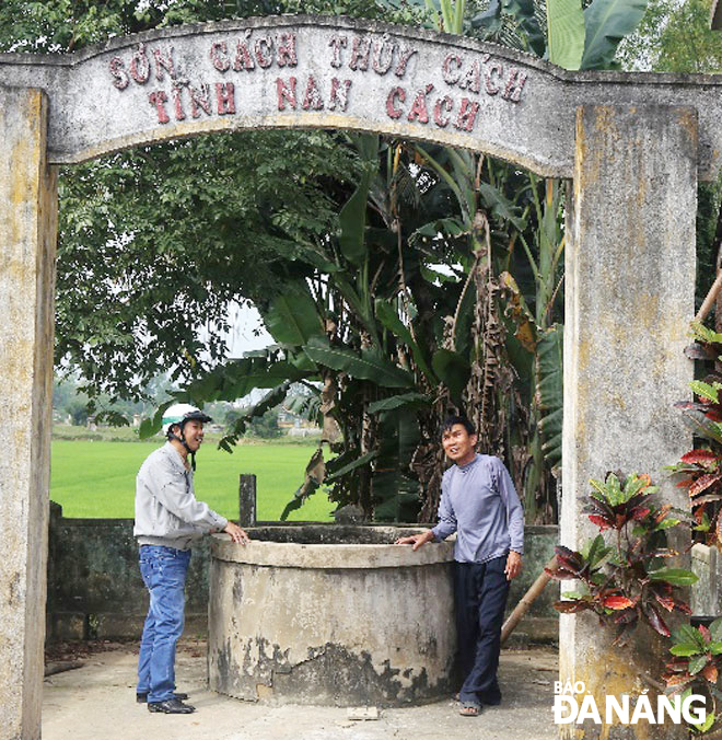 “Ông trẻ” Bùi Minh Diệu (đội mũ) chuyện trò với một người trong tộc bên giếng cổ của ông Cửu Tý. Ảnh: V.T.L