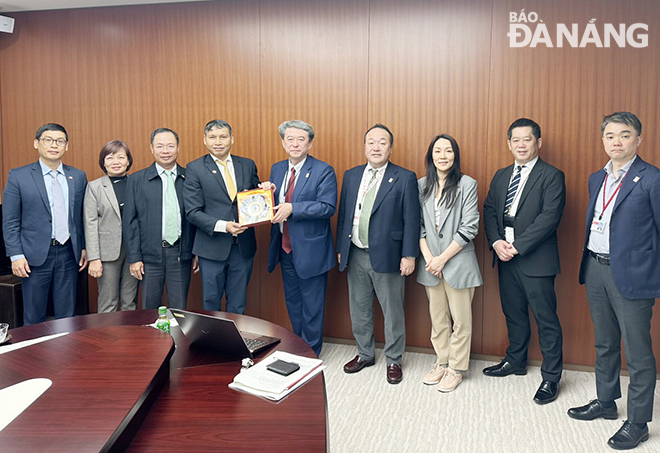 Da Nang Peoples Committee Vice Chairman Ho Ky Minh (fourth, left) presents a souvenir gift to the leaders of Mitsubishi Corporation.