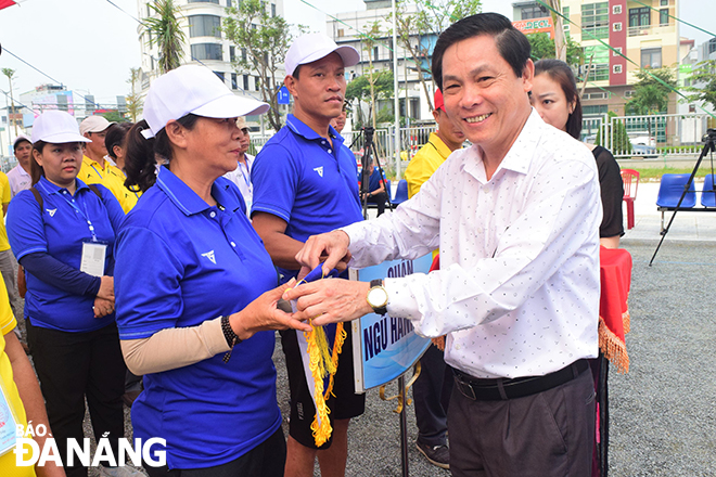 Director of the Da Nang Department of Culture and Sports Pham Tan Xu presenting souvenir flags to participating athletes