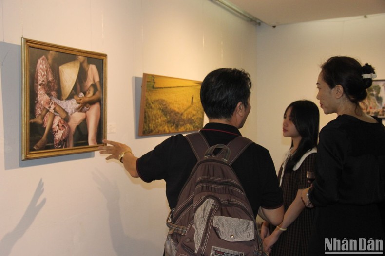 Visitors admire the photo at the exhibition. (Photo: NDO)