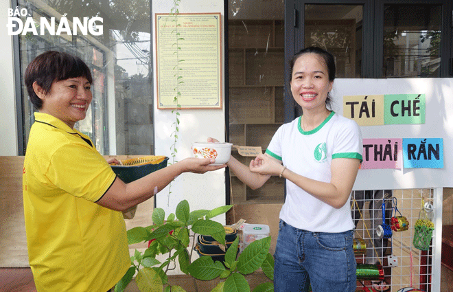 Ms. Vo Thi Kim Ngan (right) introduces a resident to a model of waste sorting at source in Hai Chau District. Photo: PV