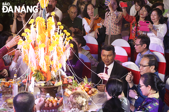 Vice Chairman of the Da Nang People's Committee Ho Ky Minh and other delegates attending a ceremony of tying strings around people's wrists. Photo: X.D