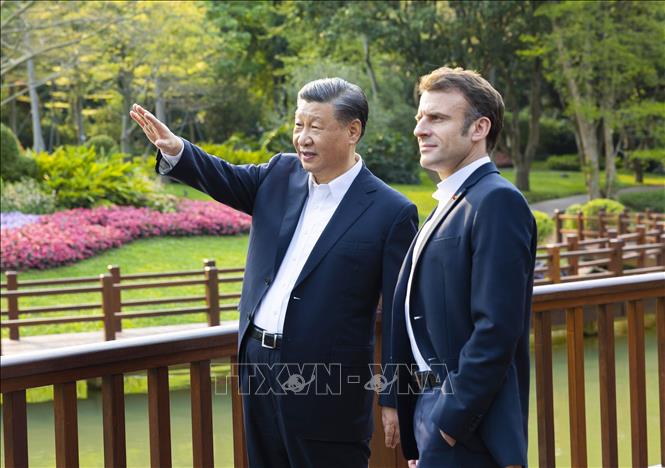 Chủ tịch Trung Quốc Tập Cận Bình (trái) cùng Tổng thống Pháp Emmanuel Macron vãn cảnh tại Vườn Thông ở Quảng Châu, tỉnh Quảng Đông ngày 7/4/2023. Ảnh: THX/TTXVN