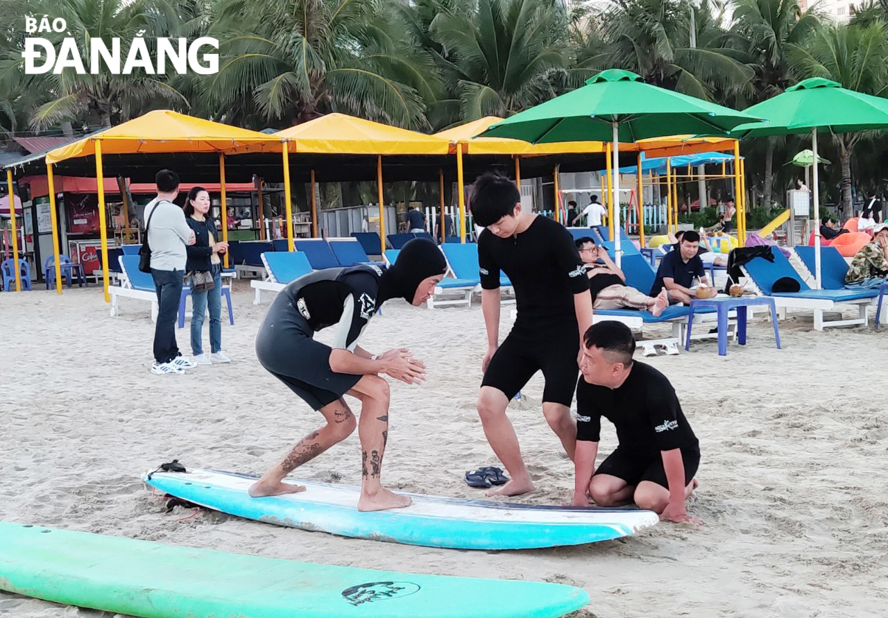 Các hoạt động thể thao, vui chơi giải trí sẽ được tổ chức tại các bãi biển để phục vụ người dân và du khách. TRONG ẢNH: Du khách đang trải nghiệm tập chơi môn thể thao lướt ván tại bãi biển Phạm Văn Đồng. Ảnh: T.H