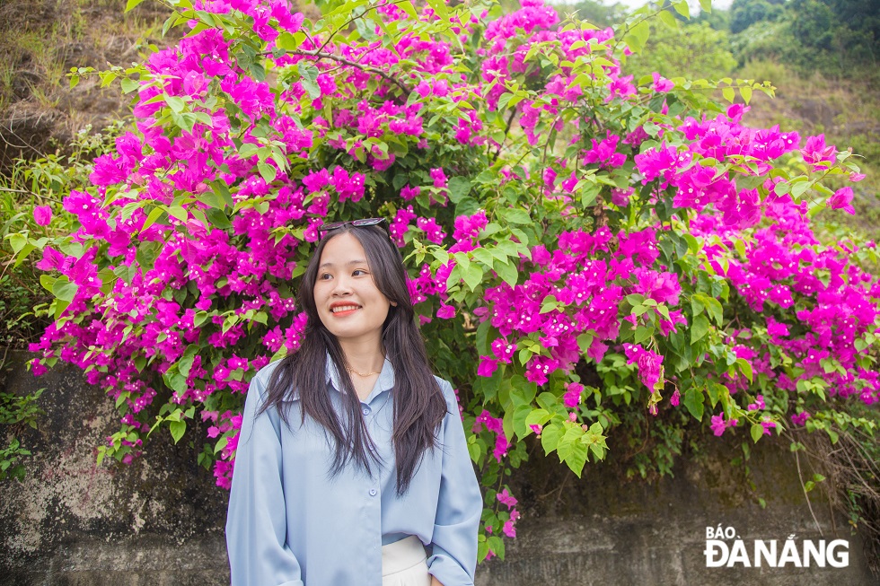 A young girl posing for a photo with bougainvillea in Son Tra Peninsula.