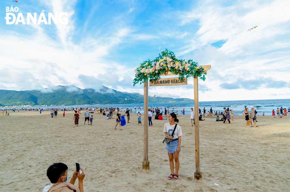 A couple is taking photos to save beautiful moments at a beach in Da Nang