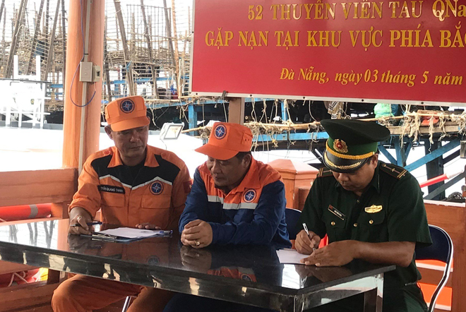 Mr. Tran Quang Thanh, the captain of rescue ship SAR 412 (first left) is handing over rescued fishermen to border guards.