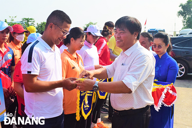 Mr. Nguyen Trong Thao, Deputy Director of the Da Nang Department of Culture and Sports cum Head of the Organising Committee of the tournament, presenting souvenir flags to the participating athletes. Photo: PN