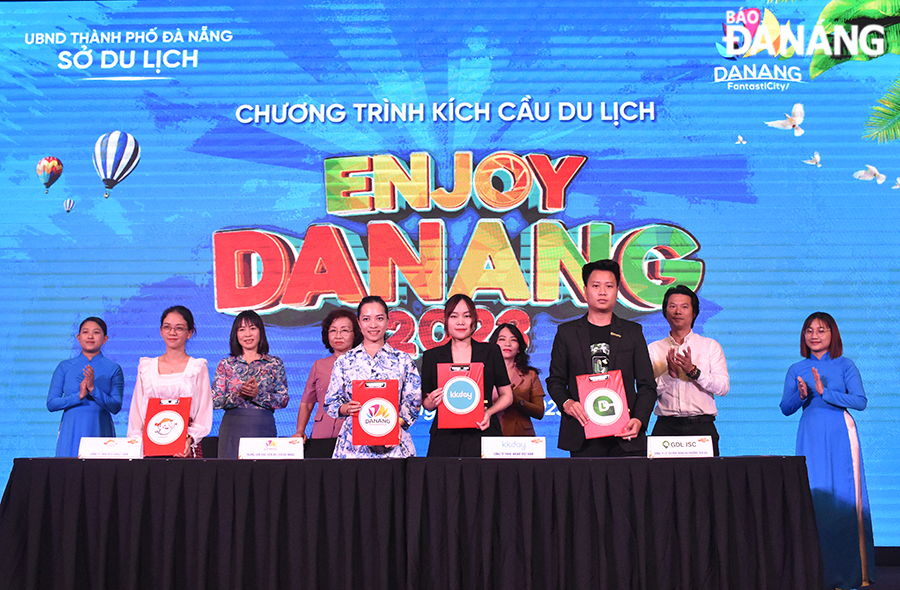 Vice Chairwoman of the Da Nang People's Committee Ngo Thi Kim Yen (4th, left) and Director of the municipal Department of Tourism Truong Thi Hong Hanh (3rd, left) gave flowers to thank the sponsors of the programme. Photo: THU HA