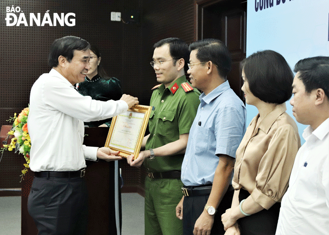 Chủ tịch UBND thành phố Lê Trung Chinh (bên trái) trao bằng khen cho các tập thể xuất sắc.  Ảnh: TRỌNG HUY