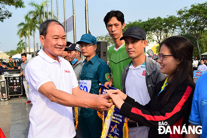 Phó Chủ tịch Ủy ban Mặt trận Tổ quốc Việt Nam thành phố Dương Đình Liễu tặng cờ lưu niệm cho các VĐV dự giải.