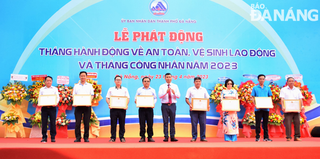 Phó Chủ tịch Thường trực UBND thành phố Hồ Kỳ Minh (giữa) trao bằng khen của Chủ tịch UBND thành phố cho đại diện các tập thể có thành tích xuất sắc trong công tác bảo đảm an toàn, vệ sinh lao động năm 2022. Ảnh: HOÀNG HIỆP