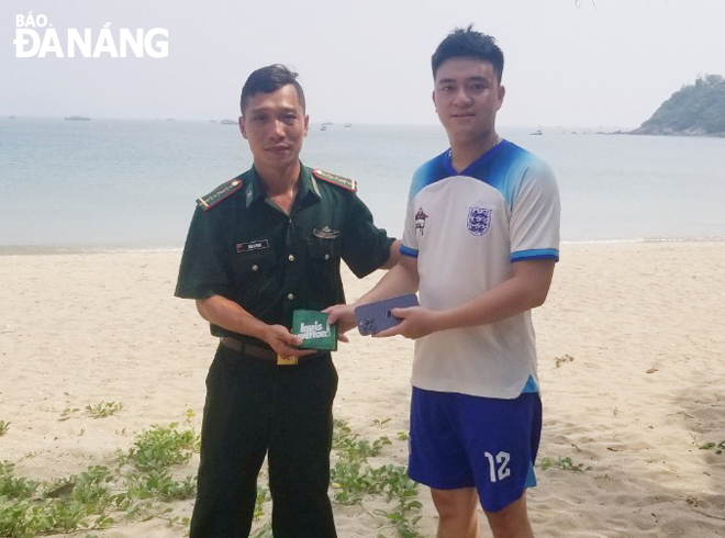 Mr. Nguyen Van Trung (left) receiving his lost property. Photo: HONG QUANG