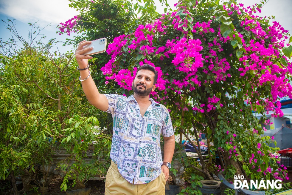 Mr. Divyank, 33, an Indian native, is taking selfie with bougainvillea when traveling in Da Nang