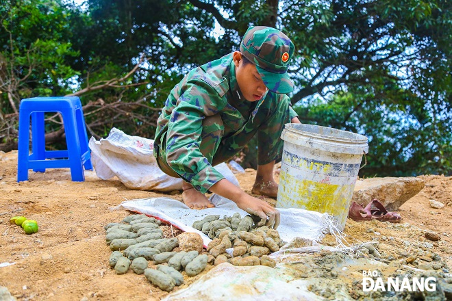 CHiến sĩ nặn đất sét làm vật che lấp những lỗ trên đá sau khi đặt thuốc nổ vào.