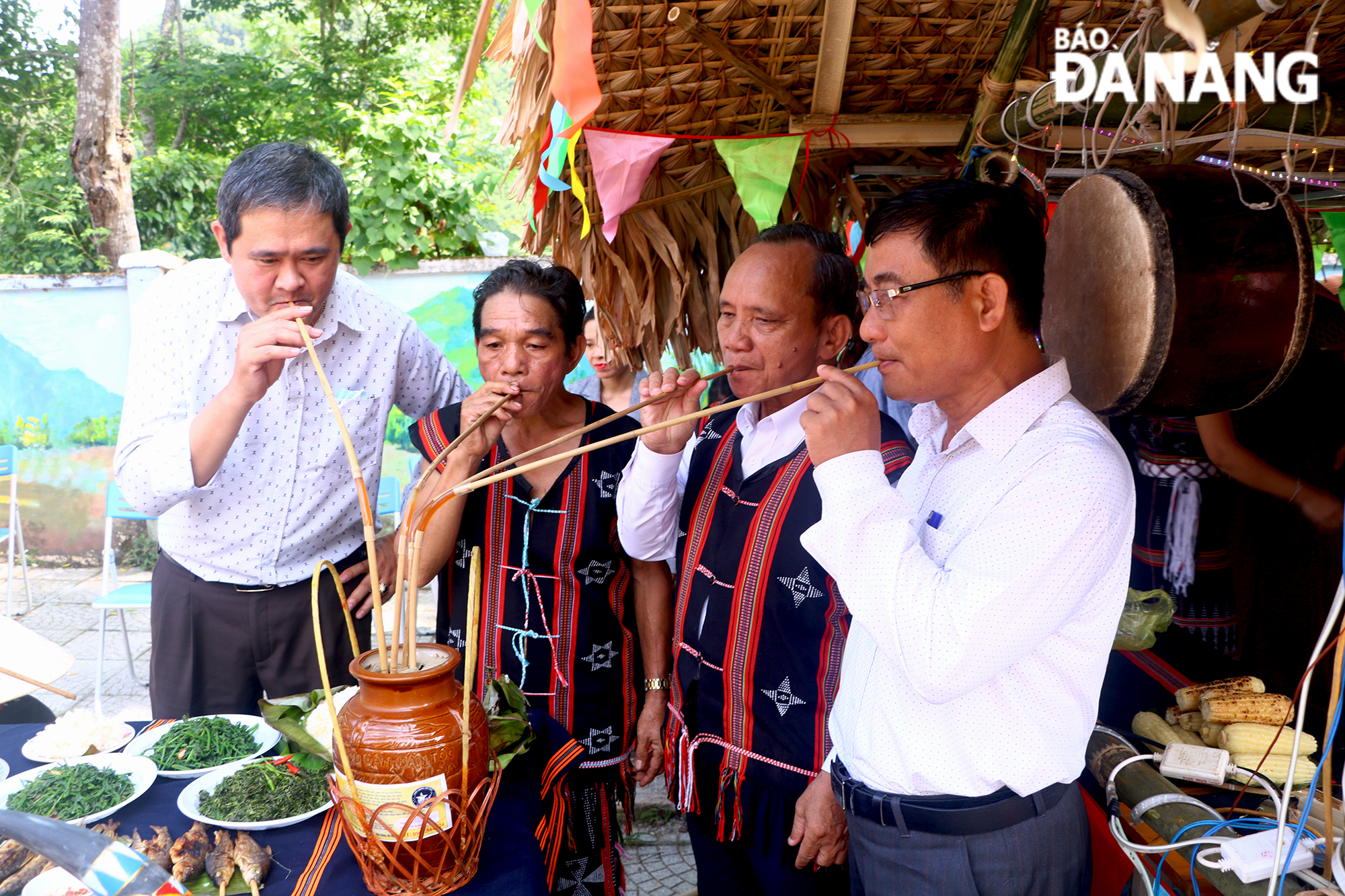 In the festival space, visitors have a chance to enjoy local specialties.In the photo: Visitors are drinking 'ruou can' (rice wine drunk out of a jar through pipes) 