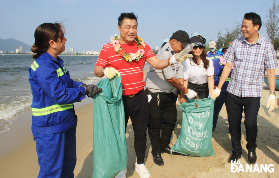 Đại sứ môi trường - diễn viên Lý Hùng (thứ 2 từ trái sang) tham gia nhặt rác tại bãi biển Đà Nẵng cùng các tình nguyện viên.