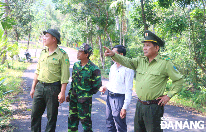 Mr Le Dinh Tham, the Head of the Hoa Vang District Forest Protection Division, (right) discussing  with owners of plantation forests how to prevent and fight wildfires in the hot weather. Photo: VAN HOANG