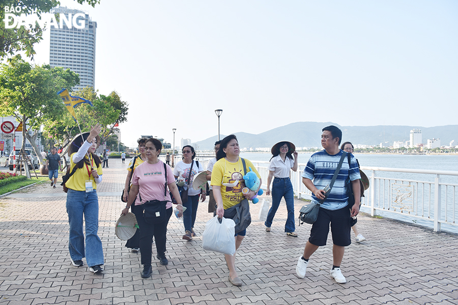 Du khách được hướng dẫn tham quan các điểm dọc bờ sông Hàn. Ảnh: THU HÀ
