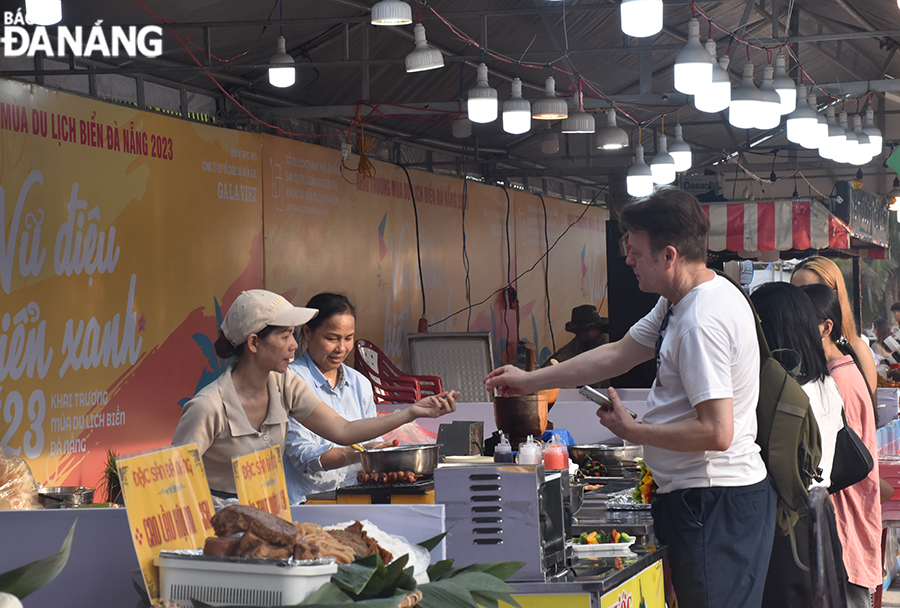 Du khách trải nghiệm không gian ẩm thực tại chương trình Khai trương mùa du lịch biển Đà Nẵng 2023 tại công viên biển Đông. Ảnh: THU HÀ