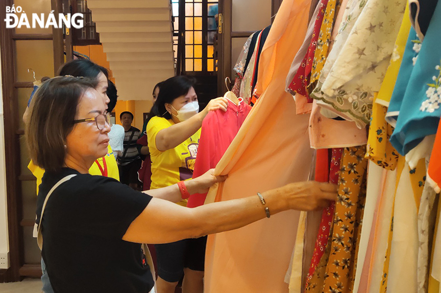 Visitors try and buy ‘Ao dai’ at Viet Sense. Photo: THU HA