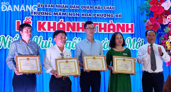 Chủ tịch UBND quận Hải Châu Lê Tự Gia Thạnh (bìa phải) trao giấy khen của UBND quận cho các tập thể, cá nhân có thành tích xuất sắc hoàn thành xây dựng Trường Mầm non Hoa Phượng Đỏ. Ảnh: HOÀNG HIỆP