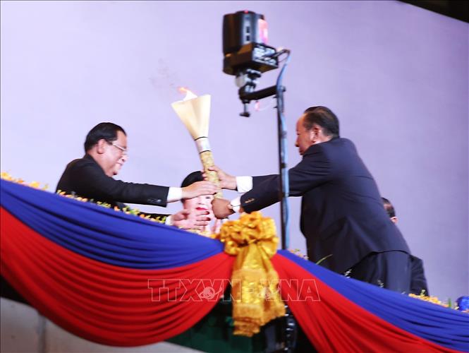 Thủ tướng Campuchia Samdech Techo Hun Sen trao ngọn đuốc Đại hội cho Phó Thủ tướng Campuchia Samdech Tea Banh - Chủ tịch Uỷ ban Tổ chức SEA Games 32. Ảnh: TTXVN