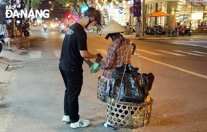 The AND group members giving a dinner consisting of milk, a dumpling and a bottled water to poor workers. Photo: T.V