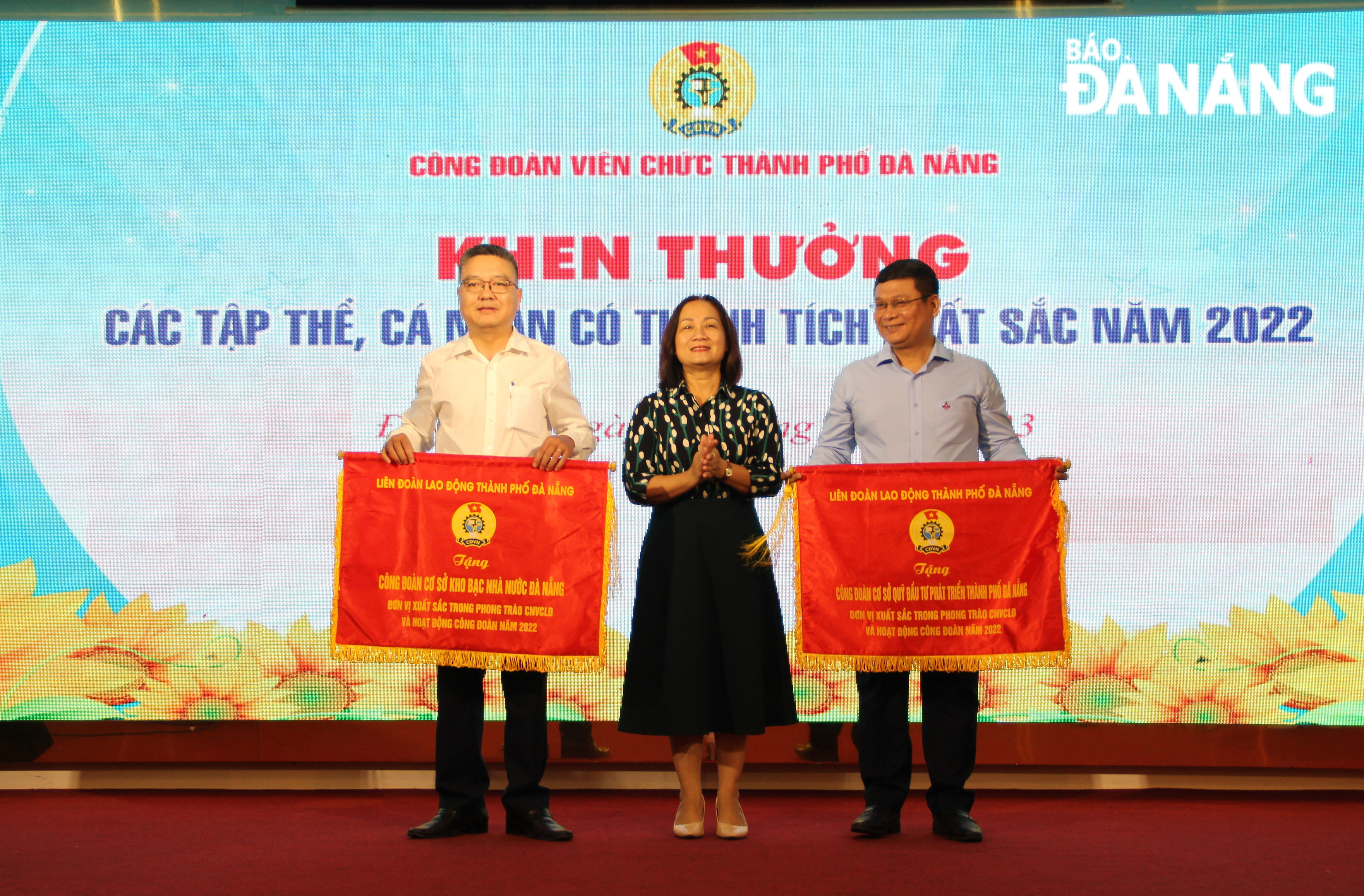 Vice Chairwoman of the Da Nang Labour Confederation Dinh Thi Thanh Ha presented emulation flags to two excellent collectives in recognition of their outstanding achievements in the movement of workers, officials and labourers. Photo: X.HAU