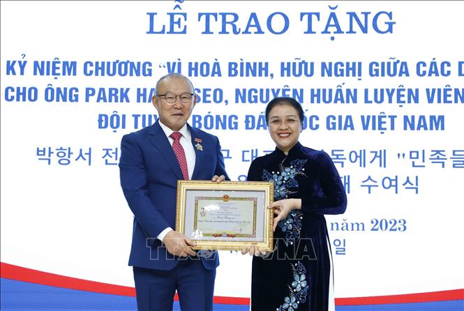 Chủ tịch Liên hiệp các tổ chức hữu nghị Việt Nam Nguyễn Phương Nga trao Kỷ niệm chương cho ông Park Hang-seo. Ảnh: An Đăng/TTXVN