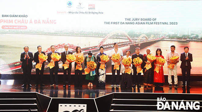 Minister of Culture, Sports and Tourism Nguyen Van Hung (first, left) and Permanent Deputy Secretary of the Da Nang Party Committee Luong Nguyen Minh Triet (first, right) presenting flowers to the jury board. Photo: X.D