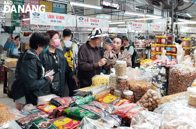 The Da Nang tourism industry is encouraging local residents, tourists and service businesses to make a positive shift to non-cash payment. Tourists are seen shopping at the Han Market in the downtown area. Photo: NHAT HA