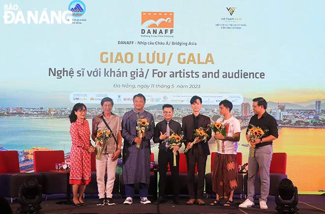 Mrs. Ly Phuong Dung (far left), Deputy Director of the Viet Nam Cinema Department gives flowers and poses for a souvenir photo with young directors and actors at the exchange meeting in Da Nang, May 11, 2023.