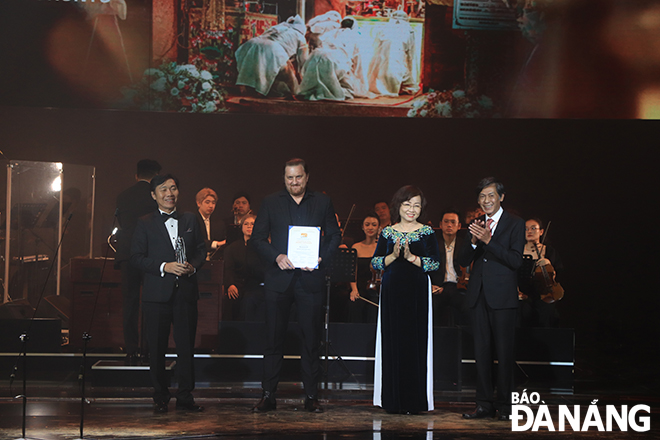 Phó Chủ tịch UBND thành phố Ngô Thị Kim Yến (thứ 2, từ phải sang) trao giải đặc biệt của Ban giám khảo phim Việt Nam dự thi cho phim “Đêm tối rực rỡ”. Ảnh: X.D