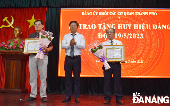 Phó Bí thư Thường trực Thành ủy Lương Nguyễn Minh Triết (giữa) trao Huy hiệu Đảng cho các đảng viên đủ tiêu chuẩn đang sinh hoạt tại các chi bộ, đảng bộ thuộc Đảng ủy khối.. Ảnh: TRỌNG HÙNG