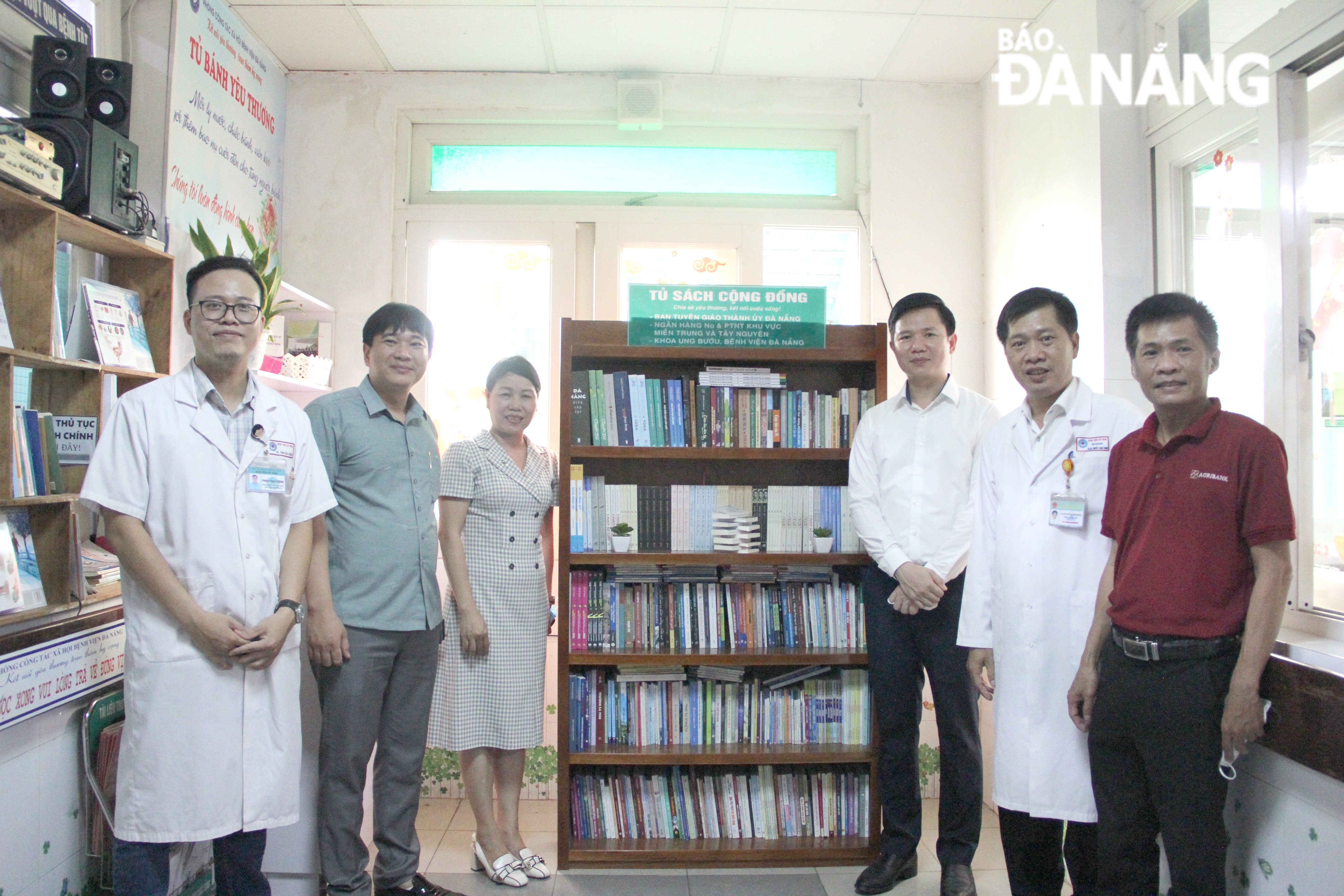 Standing Deputy Head of the municipal Party Committee's Publicity and Education Department Doan Xuan Hieu (3rrd, right) handing over the bookcase to the Oncology Department of the Da Nang Hospital 